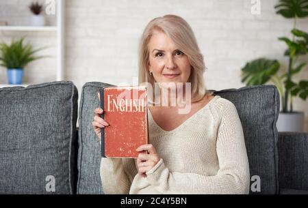 Ältere Frau lernt zu Hause englisch. Stockfoto