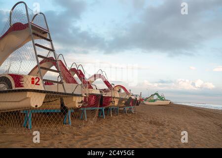 Leerer Strand in Rimini, Italien; Tretboote am Strand bei Sonnenaufgang am bewölkten Morgen Ozean Sonnenaufgang in Rivazzurra (Rimini / Italien) adriaküste Stockfoto