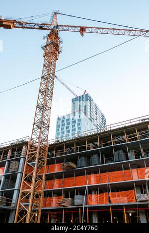 Großkrane ruhen untätig auf einer leeren Baustelle in Brooklyn Stockfoto