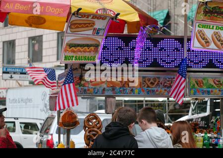 Zwei junge Jungs stehen Schlange, um Hotdogs bei A zu kaufen Street Food Cart in NY Stockfoto