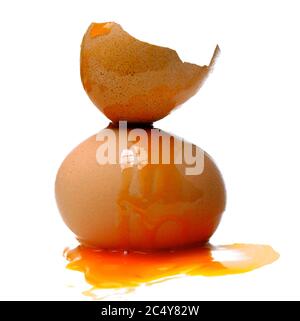 Nahaufnahme von zerbrochenen Eiern mit ausgebreiteten Eigelb isoliert auf weißem Hintergrund Stockfoto