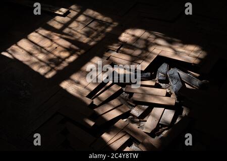 Sonne kommt durch Fenster Beleuchtung beschädigte Holzdiele in verlassenen Gebäude Raum, sonnenbeschienenen Holz Parkettboden mit verdrängten Dielen Stockfoto