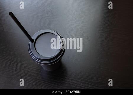 Schwarze Papiertasse Kaffee isoliert auf einem Holztisch Stockfoto