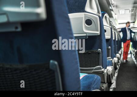 Innenraum Des Big Bus Mit Reihen Von Blue Fabric Sitze Und Schmalen Korridor. Stockfoto