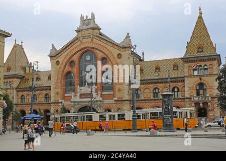 Budapest, Ungarn - 13. Juli 2015: Zentrale Markthalle am Fovam Platz mit Menschen und Straßenbahn öffentlichen Verkehrsmitteln in Budapest, Ungarn. Stockfoto