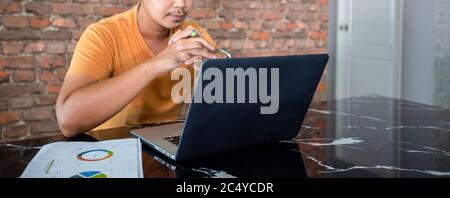 Asian Mann verwendet ein Notebook-Computer und arbeitet hart und Treffen zu Hause und er ist gestresst und Kopfschmerzen. Stockfoto