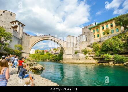 Touristen zielen auf Kameras, während ein bosnischer Taucher sich vorbereitet, von der Stari Most, alten Brücke in den Neretva-Fluss in Mostar, Bosnien und Herzegowina zu springen Stockfoto
