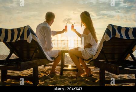 Paar trinken Cocktails am Strand während des Urlaubs oder Flitterwochen in den Tropen Stockfoto