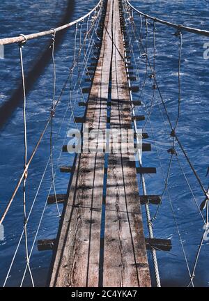 Beginn eines Abenteuers, Weg in den Dschungel. Hängebrücke. Landschaftsansicht der langen Stahlhängebrücke über dem Fluss. Balance. Stockfoto