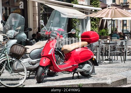 Mailand, Italien 06.29.2020: Ein gewöhnlicher Mailänder Straßenblick mit einem roten Piaggio Vespa Roller Stockfoto