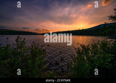 Sommersonnenwende Sonnenuntergang auf einem See in Catskills Mountains, NY, USA Stockfoto