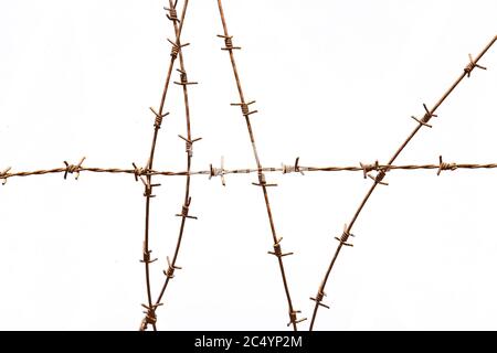 Gewickelte Stacheldraht-Zäune isoliert auf weißem Hintergrund Stockfoto