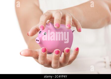 Save Investment-Konzept. Zwei Frauenhände schützen Pink Piggy Bank auf weißem Hintergrund. Stockfoto