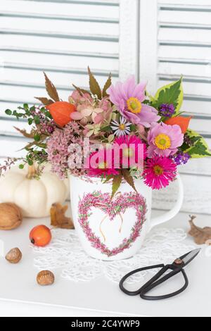 Romantisches Bouquet von Herbstblumen in rosa in Tasse Stockfoto