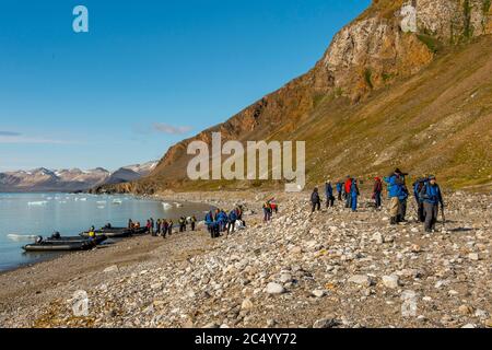 Touristen auf dem felsigen Strand in der Bucht des Fjortende Julibreen (der 14. Juli Gletscher), befindet sich im Nordwesten Spitzbergen im Krossfjord, S Stockfoto