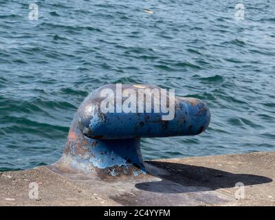 Ein rostiger Seeschiff, der Stollenstalle oder Poller auf einem festmachen soll pier am Ufer Stockfoto