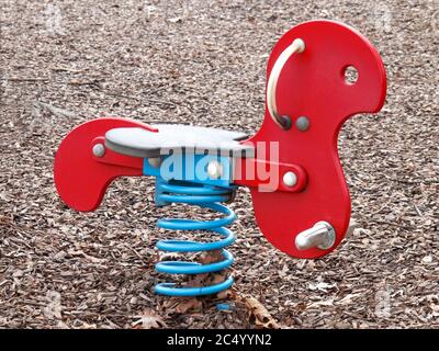 Ein buntes Kinderfrühlingsschaukelpferd auf einem Spielplatz Stockfoto