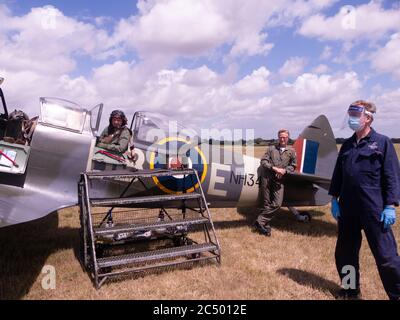 Ein Passagierflug in einer Supermarine Spitfire IX bei Aero Legends, Headcorn (Lashenden), Kent, UK. Die Bodencrew trägt PSA für Coronavirus Covid-19 Stockfoto