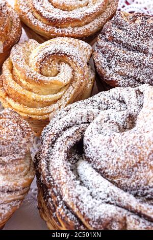 Hausgemachter moderner Cruffin-Kuchen, Hefe gerollter Zimt-Brötchen, bestreut mit Puderzucker. Speicherplatz kopieren. Hintergrund. Nahaufnahme. Stockfoto