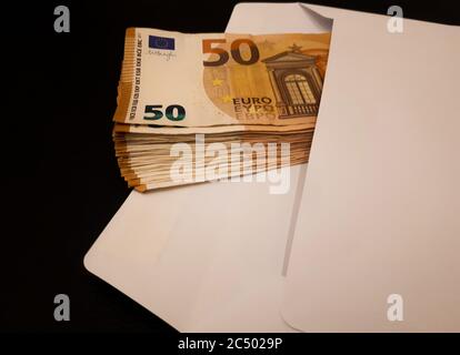 Bündel von Euro-Banknoten in weißem Umschlag: Verschiedene Konzepte Stockfoto
