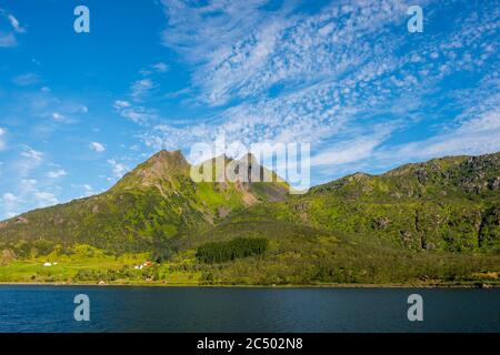 Häuser und Hütten entlang der Raftsund, eine Wasserstraße der Norwegischen See in Nordland County, Lofoten Islands, Norwegen. Stockfoto