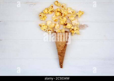 Ansicht von oben auf Eis-Kegel mit Popcorn auf weißem Holztisch Stockfoto