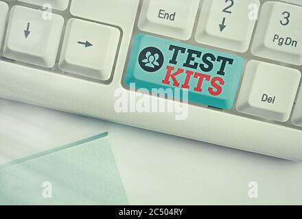 Testkits für die Handschrift von Texten. Konzeptionelle Foto-Tools verwendet, um die Anwesenheit von etwas im Körper erkennen White pc-Tastatur mit leeren Note pape Stockfoto