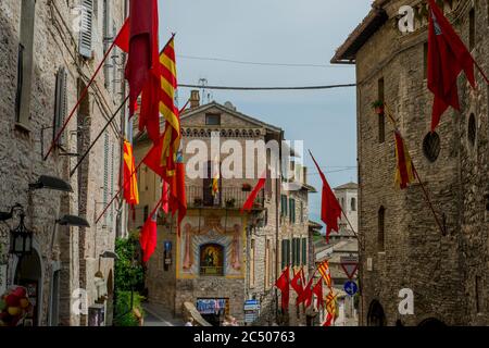 Die Straßen der historischen Stadt Assisi, in der Provinz Perugia in der Region Umbrien in Italien, sind mit Fahnen während der Festa di Cal geschmückt Stockfoto