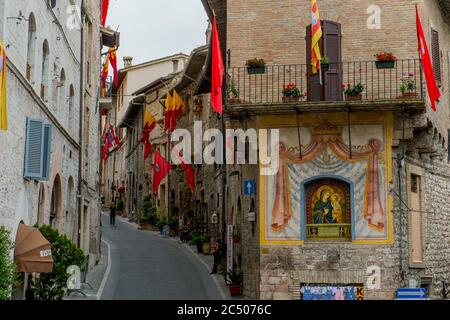 Die Straßen der historischen Stadt Assisi, in der Provinz Perugia in der Region Umbrien in Italien, sind mit Fahnen während der Festa di Cal geschmückt Stockfoto