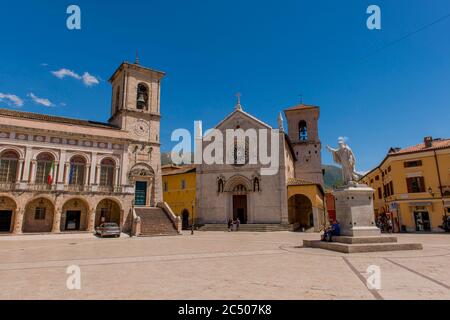 Blick auf das Rathaus, die Kirche und die Statue des Heiligen Benedikt auf dem Hauptplatz der Stadt Norcia in der Provinz Perugia im Südosten Umbriens, Stockfoto