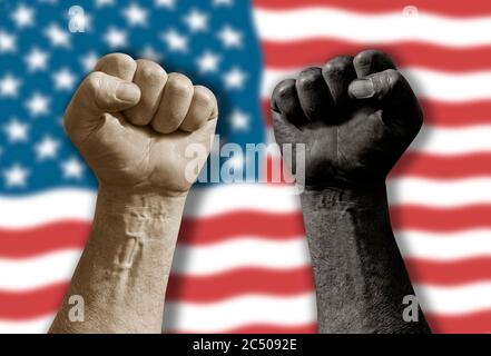 Erhöhte schwarz-weiße Faust vor verschwommener winkender amerikanischer Flagge. Diversity Segregation und Rassismus Konzept. Stoppt die Gewalt an die afrikanische Amer Stockfoto
