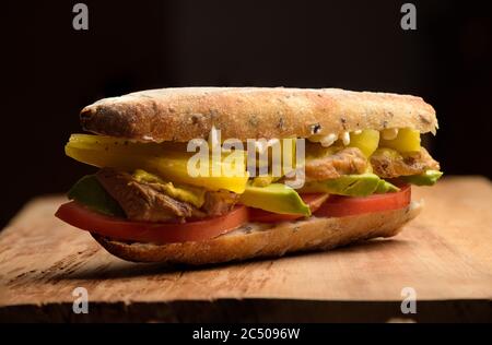 Fleischsandwich mit Avocado, Tomaten, Mayo, Chili in einem Baguette Stockfoto