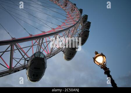 Die Passagierpods des London Eye mit einer Straßenlampe und blauem Himmel Hintergrund. Stockfoto