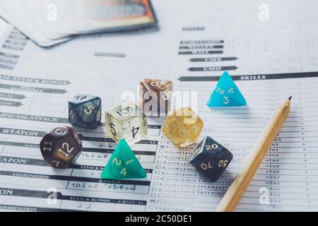 Bunte Würfel und Bleistift auf einem Zeichenblatt. Rollenspiel oder rpg Konzept. Stockfoto