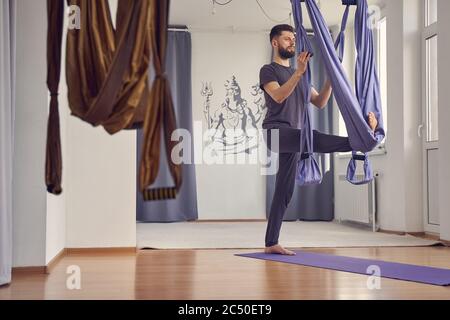 Ernst junger Mann tun Luft Yoga-Übung Stockfoto