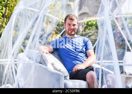 Besitzer Josh Green in einem der klimatisierten Outdoor-Dining Pods, die für die soziale Distanzierung von Gästen im Barn Restaurant, Terrington St. John, Norfolk entworfen wurden. Stockfoto