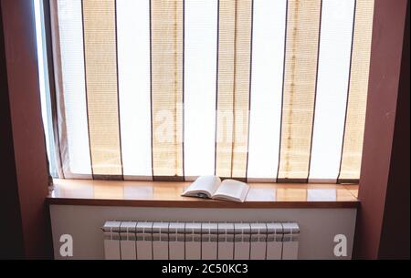 Buch auf der Kante eines großen Fensters Stockfoto