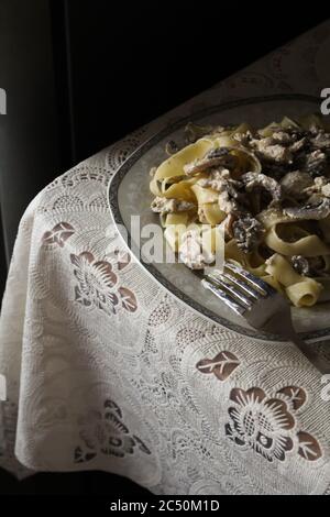 Köstliche cremige Pasta mit Pilzen auf einem Teller zum Abendessen Stockfoto