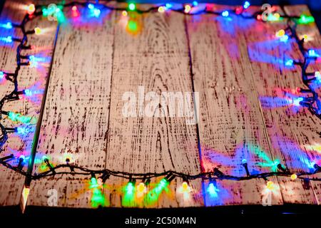 Hölzerne alte Tabelle in festlichen rot blau gelb grün Lichter an den Rändern des Fotos befindet. Festliche bunte Lichter in schönem Bokeh. Fr. Stockfoto