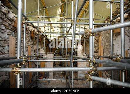 Innenräume der kleinen Kirche der Madonna della Cona, in der Nähe von Castelluccio di Norcia, mit Verstärkungsstrukturen, um Erdbebenschäden zu beheben. Stockfoto