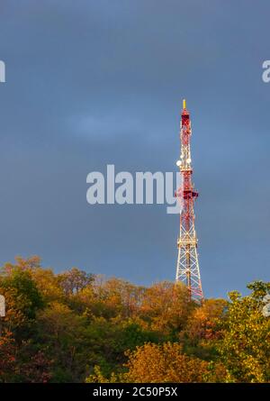 Funkturm auf einem Hügel am Abendhimmel Hintergrund nach Sturmregen Stockfoto