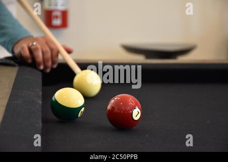 Schwarzer Billardtisch, Billard spielen - Nahaufnahme eines Mannes, der Billard spielt Stockfoto