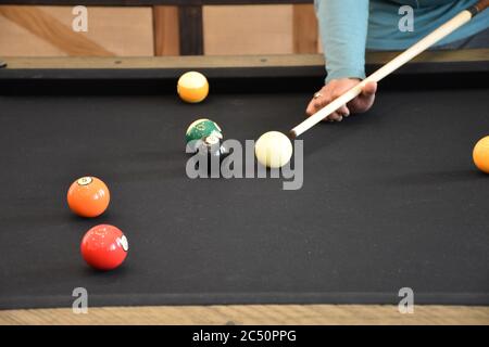 Schwarzer Billardtisch, Billard spielen - Nahaufnahme eines Mannes, der Billard spielt Stockfoto