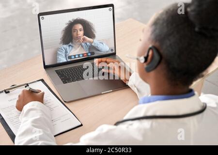 Afrikanische Arzt sprechen Sie mit Patienten durch Online-Webcam-Videoanruf auf Laptop-Bildschirm. Stockfoto