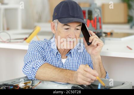 Senior woman Befestigung elektrischen Stecker Stockfoto