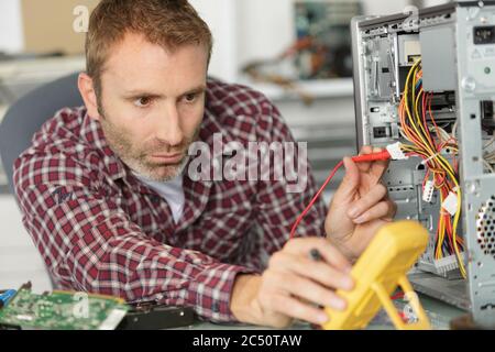 Techniker, der Spannungsmesser für einen Computer verwendet Stockfoto