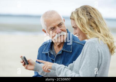 Vater und Tochter überprüfen ein Telefon Stockfoto