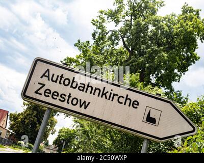 Zeestow, Deutschland. Juni 2020. Das Schild weist den Weg zur Autobahnkirche Zeestow in Brandenburg. Die Autobahn- und Dorfkirche in der Gemeinde Brieselang ist ein Backsteingebäude aus dem Jahr 1850. Seit 2014 ist sie die erste Autobahnkirche am Berliner Ring. Die Dorfkirche ist als historisches Denkmal bezeichnet. Quelle: Paul Zinken/dpa-Zentralbild/ZB/dpa/Alamy Live News Stockfoto