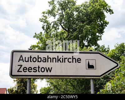 Zeestow, Deutschland. Juni 2020. Das Schild weist den Weg zur Autobahnkirche Zeestow in Brandenburg. Die Autobahn- und Dorfkirche in der Gemeinde Brieselang ist ein Backsteingebäude aus dem Jahr 1850. Seit 2014 ist sie die erste Autobahnkirche am Berliner Ring. Die Dorfkirche ist als historisches Denkmal bezeichnet. Quelle: Paul Zinken/dpa-Zentralbild/ZB/dpa/Alamy Live News Stockfoto