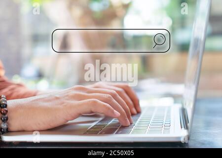 Menschen Hand mit Laptop oder Computer Suche nach Informationen im Internet Online-Gesellschaft Web mit Suchfeld Symbol und Copyspace. Stockfoto